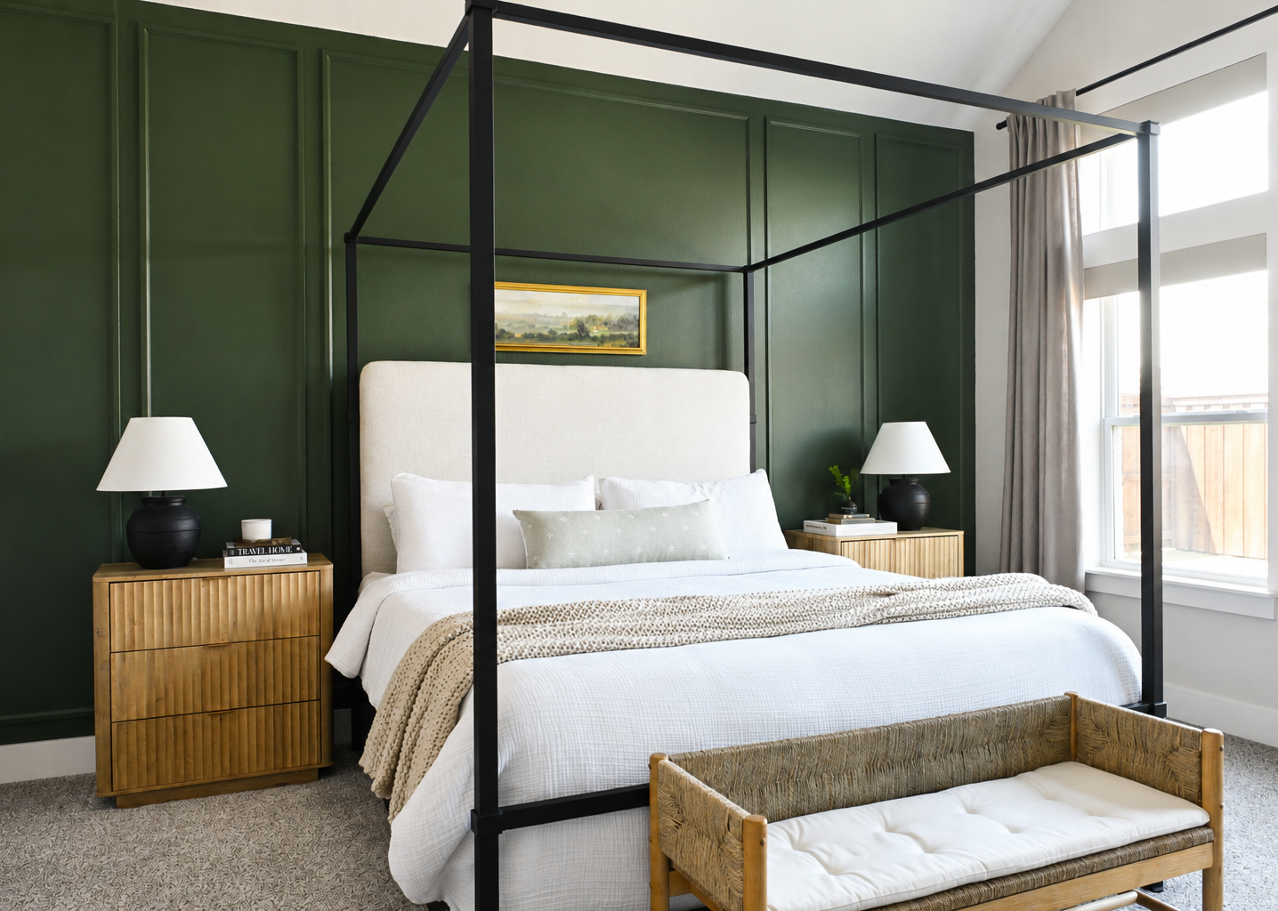 Primary bedroom with deep green paneled walls, four-poster bed, and wood nightstands