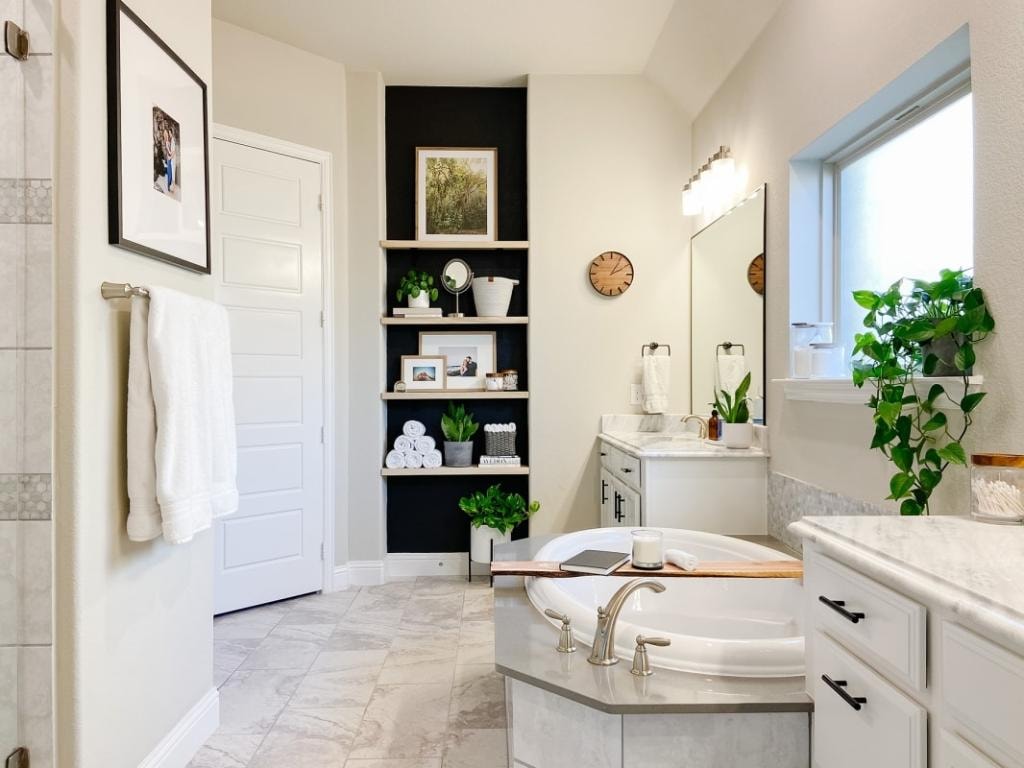 Primary bathroom with soaking tub and black accent shelving